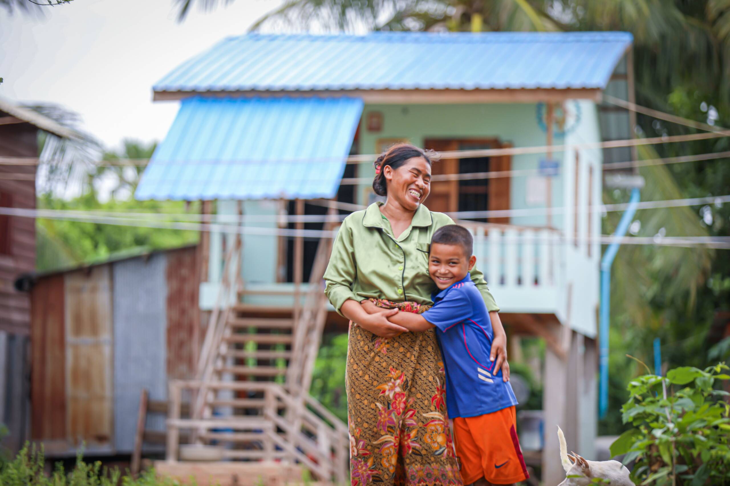 Moeder en zoon voor hun energiezuinige huis in Cambodja