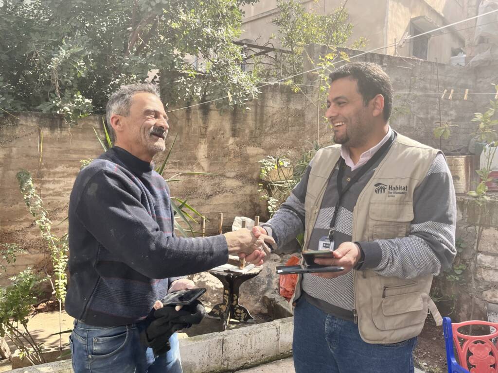 Twee mannen die praten over de verduurzaming van een woning in Jordanië.