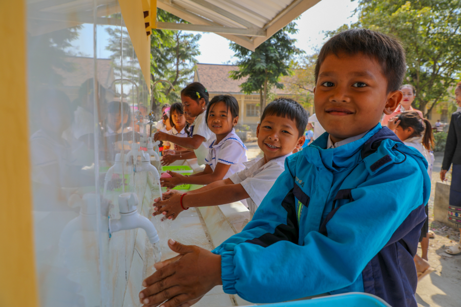 Kinderen in Cambodja wassen hun handen tijdens een WASH-training.