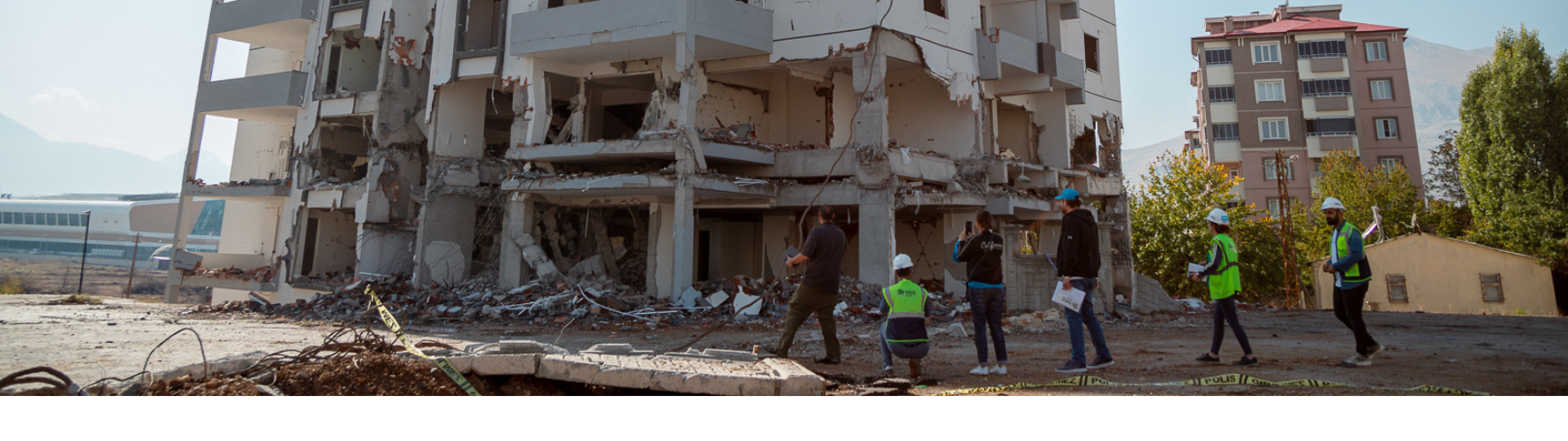 Werknemers van Habitat bekijken een beschadigd gebouw in Turkije.